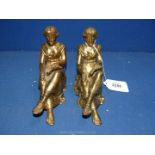 A pair of brass book ends depicting ladies reading.