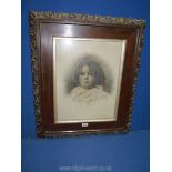 A large wooden framed picture taken from a photograph of a young girl in antique frame.