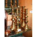 Two pairs of brass candlesticks with pushers, 13 3/4'' and 11 3/4'' tall.