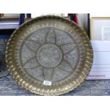 A heavy brass wall hanging plaque or tray having heavy decoration throughout, star shape to centre.