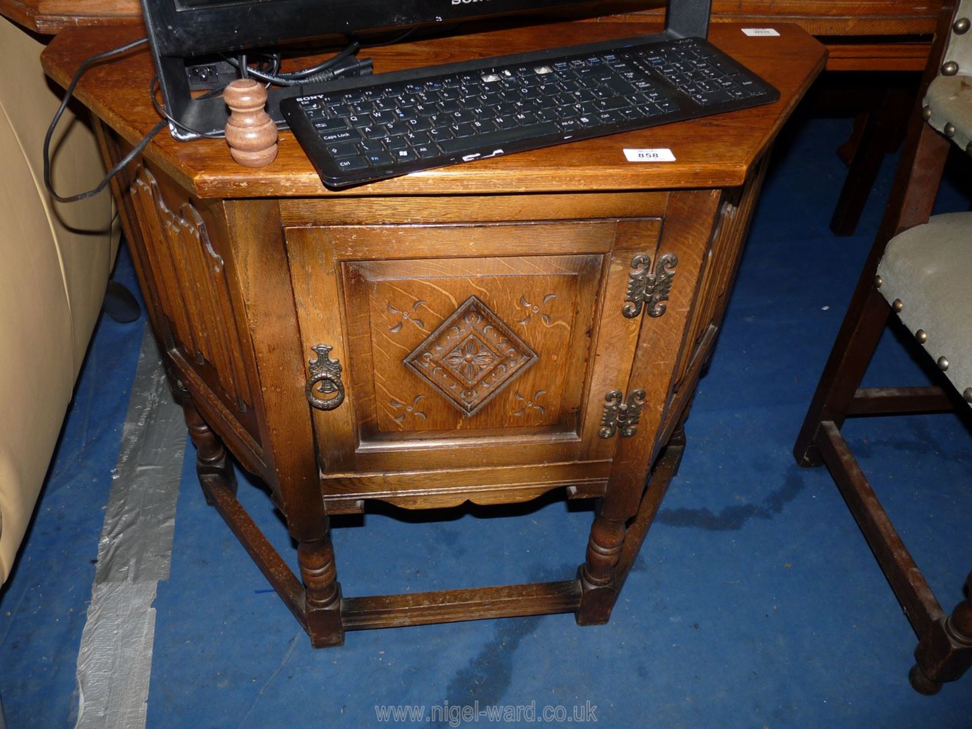 A hall cupboard with angled edges and carved door, 32" wide x 14" deep x 27 1/2" high.