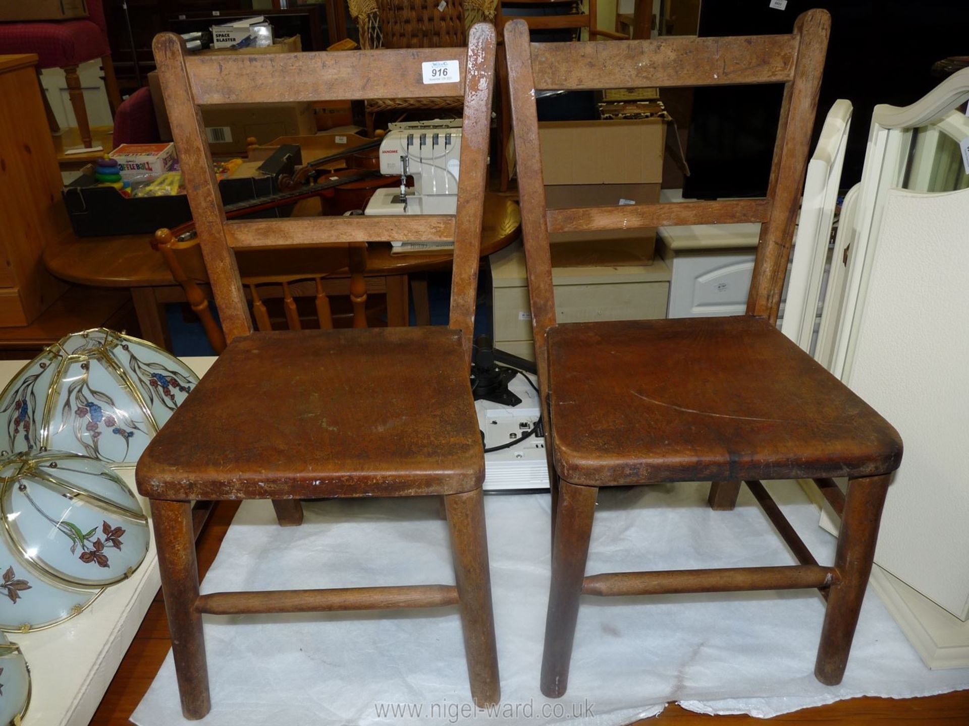 A pair of wooden children's nursery chairs.