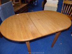 A lightwood finish extending dining table with 2 chairs.