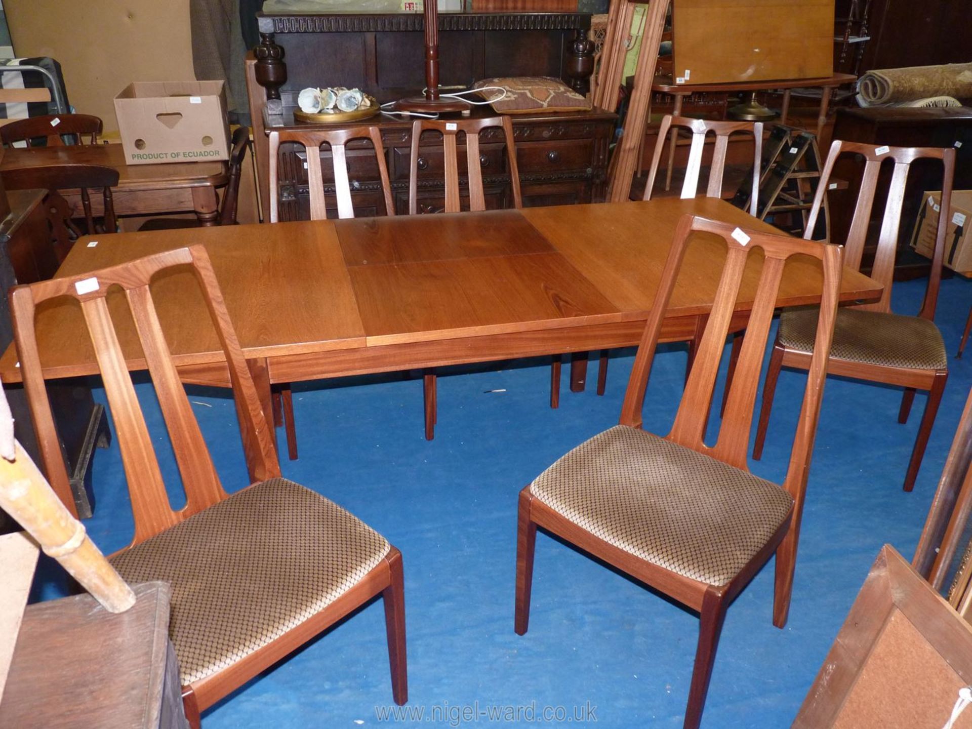 A Nathan extending dining table in a darkwood finish with 6 chairs having geometric upholstered