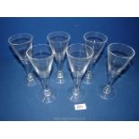 Six funnel shaped wine glasses with teardrop detail within the stems.