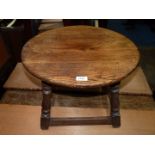 A circular Oak Occasional Table standing on four splay feet with perimeter stretchers,