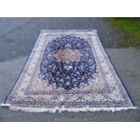 A large blue ground Rug with central cream and red medallion, 118'' x 78''.