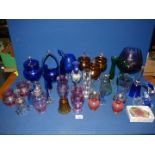 A good quantity of coloured glass including amber stemmed bon bon dish with lid, blue vases, bells,