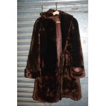 A long brown fur Coat by Daphne Butler with side pockets and turned up cuffs. Size Large.