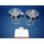 A pair of ornate glass candlesticks each with three icicle form droplets,