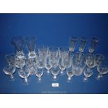 A quantity of glasses including tumblers, champagne flutes, floral engraved liqueur glasses etc.