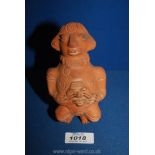 A Columbian style pottery figure of a man sitting down.