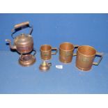 A small copper kettle on stand and three measuring jugs