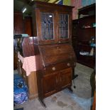 A 1930's/40's Oak student's type Bureau having leaded glazed doors to the upper bookcase section,