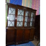 A Mahogany Breakfront Bookcase having four 13 pane doors revealing adjustable book shelving and