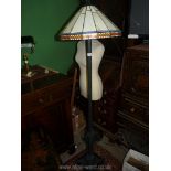A Tiffany style standard Lamp with geometric yellow and orange panels, on black metal stand,