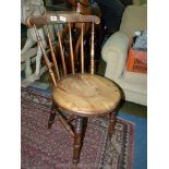 A Welsh Cottage kitchen Chair having a circular seat and turned legs and stick back.