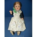 A porcelain headed Doll with sound box, sleeping eyes, plaited hair under a scarf,