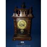A Mantle clock, the face with Roman numerals, galleried pediment, pendulum and key,