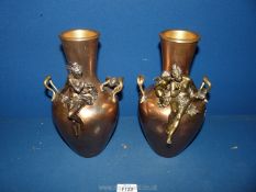 A pair of Copper Vases with applied brass nymphs and cherub figures. 10 1/2" tall.