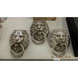 Three silvered lions head door knockers