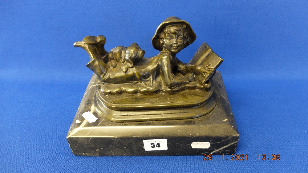 A bronze of a boy reading a book,