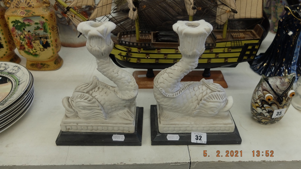 A pair of marble Dolphin candlesticks,