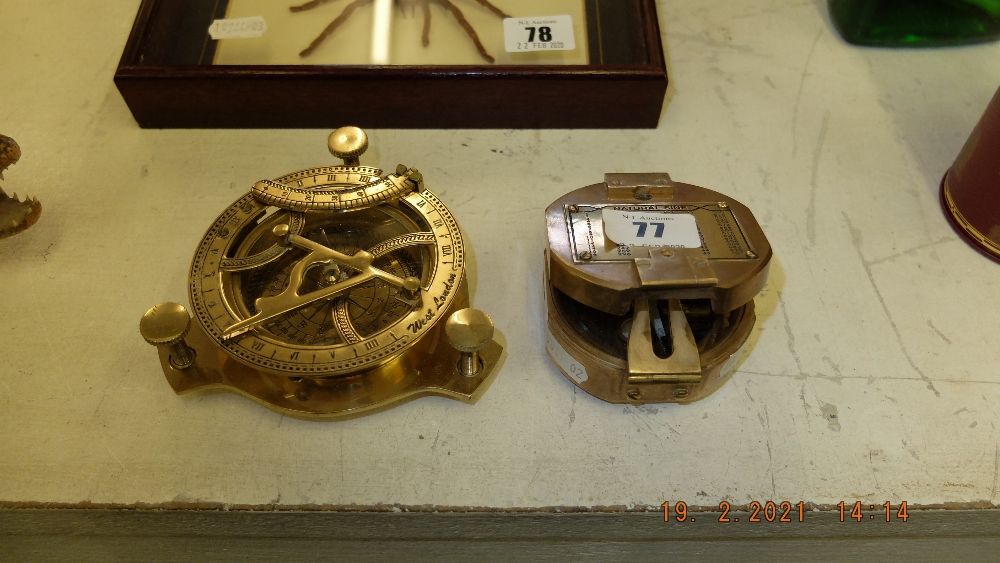 Two brass compasses one with a sundial