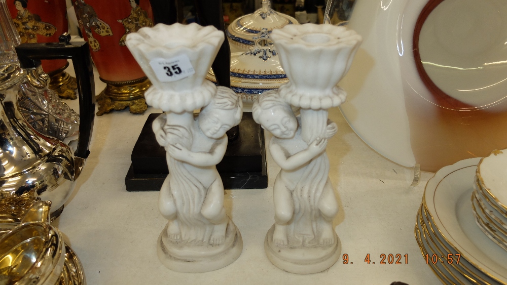 A pair of marble Cherub candlesticks