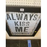 A framed sign 'Always Kiss Me'