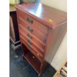 A music cabinet with fall front drawers