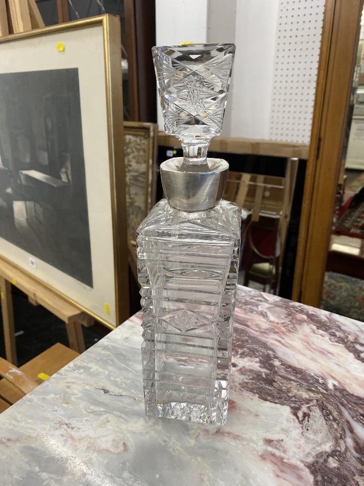 A cut glass decanter with a hallmarked Silver collar