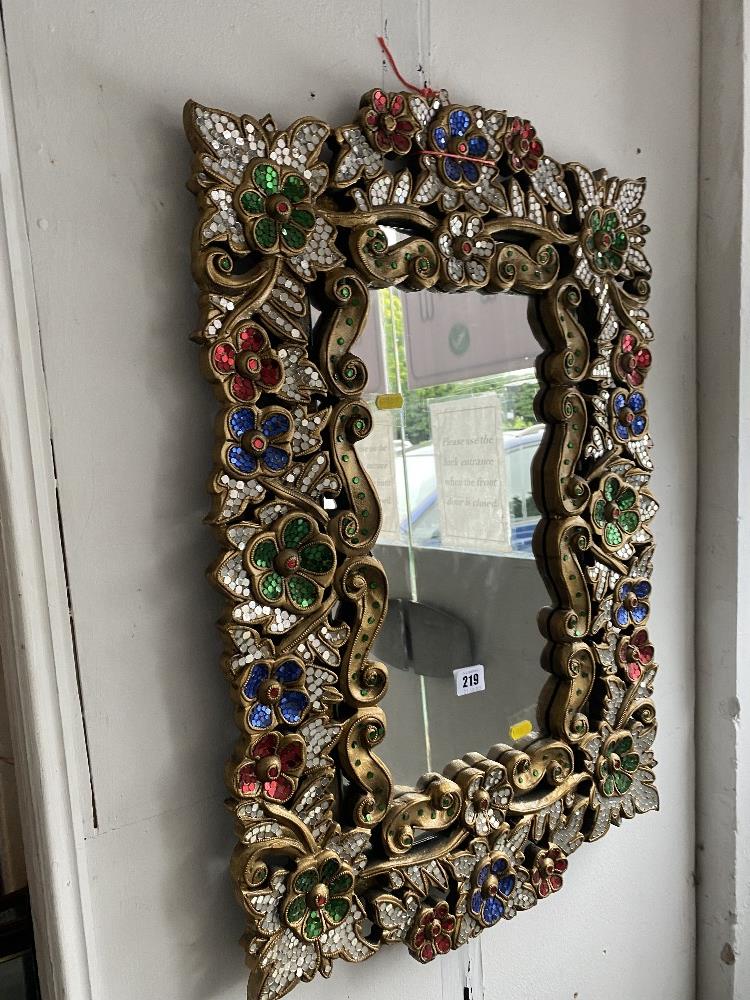 A gilt and jeweled mirror