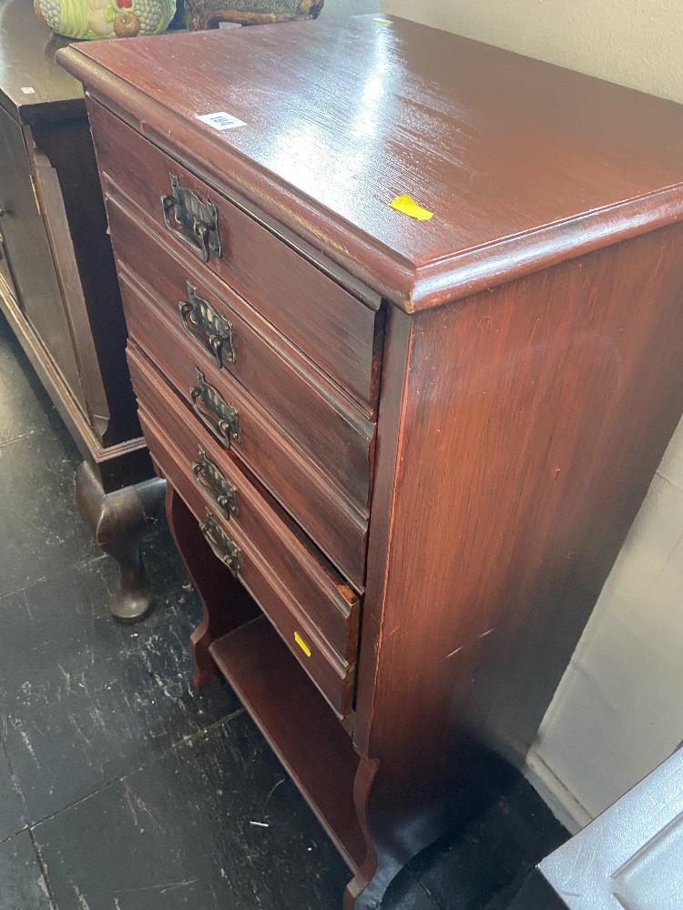 A music cabinet with fall front drawers