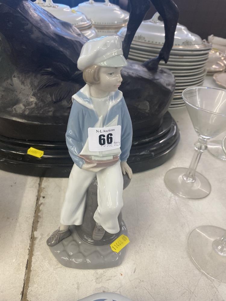 A Lladro figure, sailor boy holding a boat,