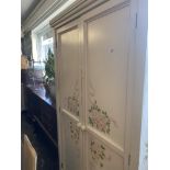 A decorative painted child's wardrobe with under drawer (two hanging rails) and matching two over