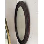 An oval framed mirror