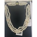 A three row cultured Pearl necklace on and 18ct Gold continental clasp set with Emeralds and
