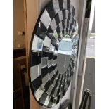 A circular black and silver mirror