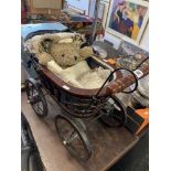 A Victorian style child's pram and teddy bear