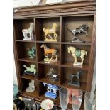 A collection of 12 Horse figures with display cabinet