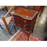 A reproduction mahogany three door cabinet with glass top