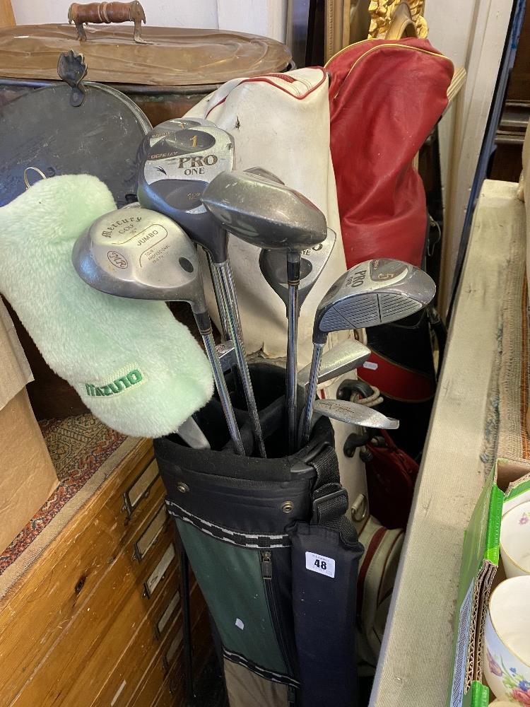 Three sets of golf clubs in bags