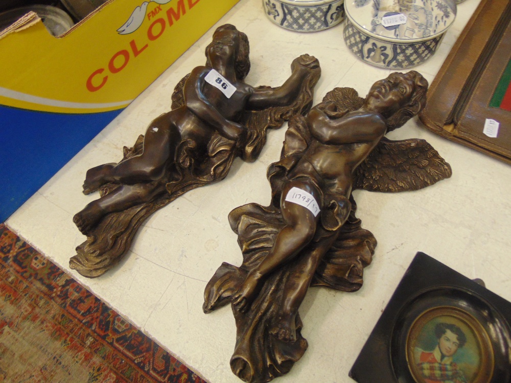 A pair of bronze wall cupids