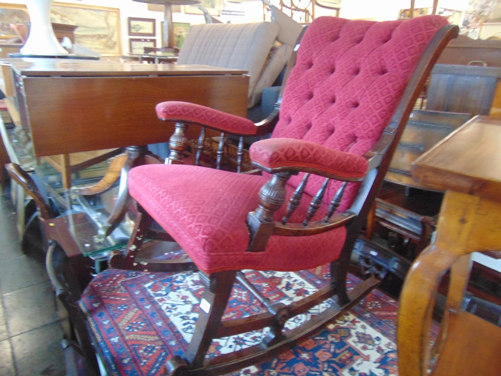 An upholstered button back rocking chair