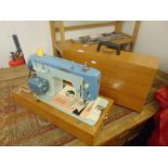 A hand sewing machine in carry case