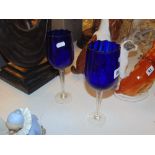 A pair of tall blue twisted glasses