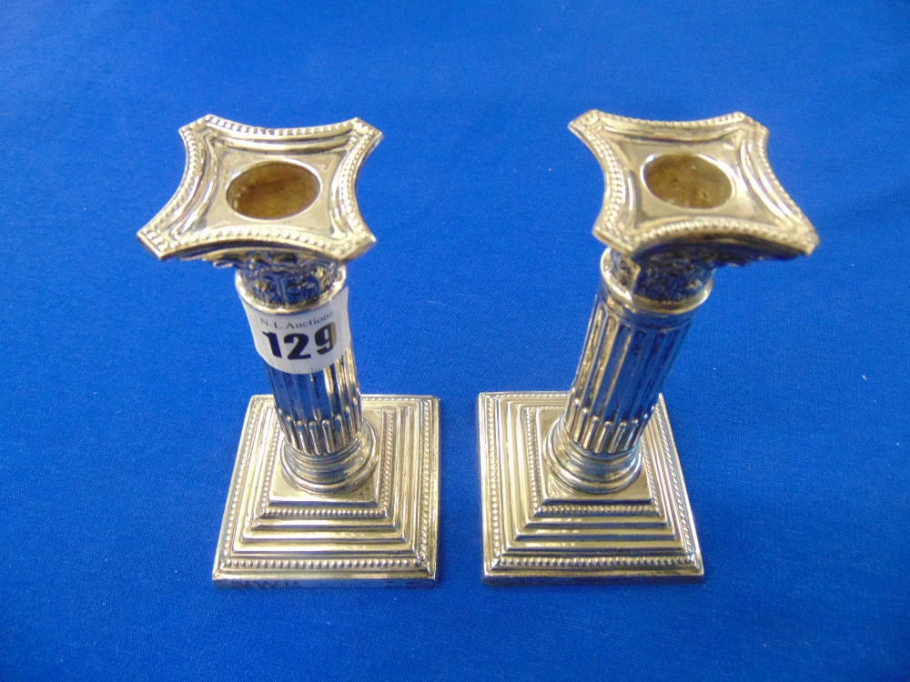 A small pair of hallmarked silver candlesticks, approx.