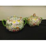 A pair of lidded twin handled pots, hand painted floral design,