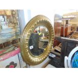 A circular brass framed mirror